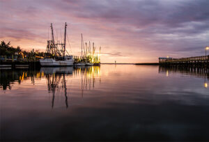 Sunset over Shem Creek in Mount Pleasant, South Carolina with the fishing boats in the distance.